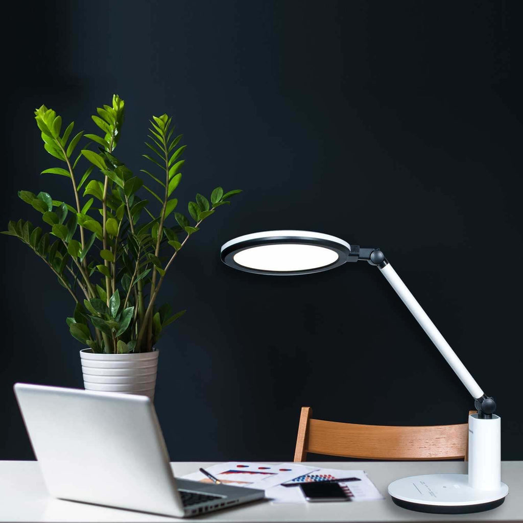 Lumeno LED Tischleuchte beleuchtet Schreibtisch mit Laptop am Abend